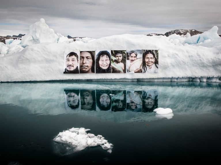 Barbara Dombrowski hat Porträts von Menschen aus Grönland und dem Amazonas an einen Eisberg gehängt.