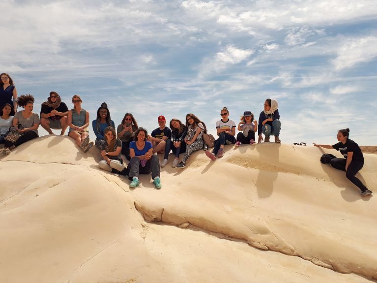 while German pupils climb rock formations in the Negev Desert