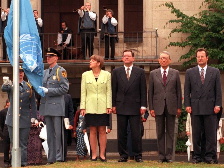 Le drapeau de l’ONU a été hissé à Bonn en 1996. Angela Merkel, alors ministre de l’Environnement, le ministre du Développement Carl-Dieter Spranger, le secrétaire général de l’ONU Boutros Boutros-Ghali et le ministre des Affaires étrangères Klaus Kinkel étaient présents. 