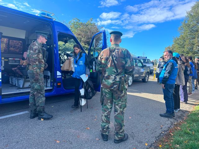 Uniformierte stehen um einen Kleintransporter herum.