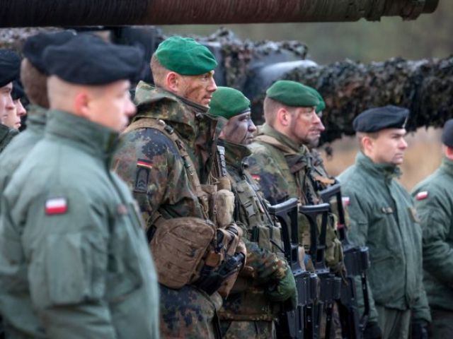 Deutsche und polnische Soldaten stehen in Reihe nebeneinander