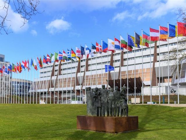 Landesflaggen und Denkmal für die Menschenrechte am Haupteingang des Europapalasts, dem Sitz des Europarats (Council of Europe / CoE) 