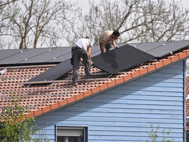 Montage von Solarpanels auf einem Hausdach 