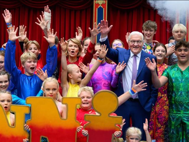 Bundespräsident Frank-Walter Steinmeier und seine Frau Elke Büdenbender stehen beim Bürgerfest von Bundespräsident Steinmeier im Park von Schloss Bellevue mit den jungen Artistinnen und Artisten vom Kinderzirkus Giovanni aus Hannover zusammen.  