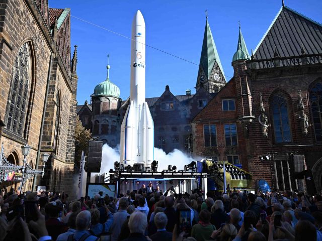 Weißer Ariane-Raketennachbau auf einer Bühne vor historischen Gebäuden 