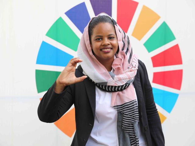 Nisreen Elsaim formt ein C für „climate change“.