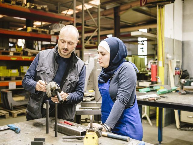 Ein Mann und eine Frau mit Migrationshintergrund in der Wertkstatt