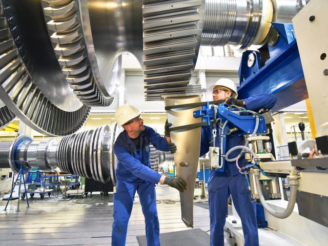 Arbeiter montieren und bauen Gasturbinen in einer modernen Industriefabrik