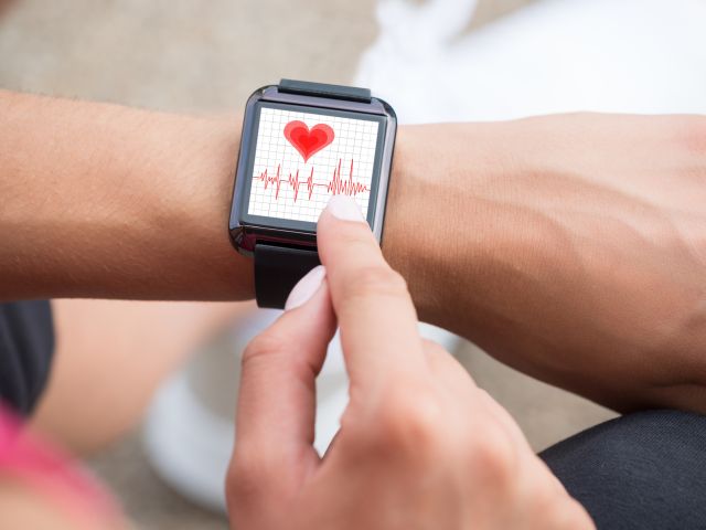 Hand mit Wearable und Gesundheits-App 