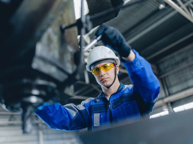 Ein Arbeiter an einer Bedienungsmaschine in der industriellen Werkstatt