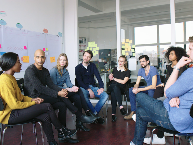 Menschen bilden einen Stuhlkreis.