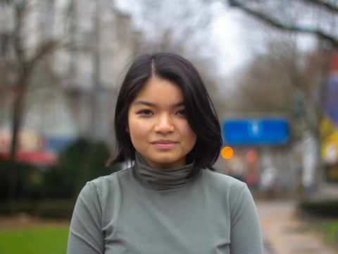 Eine junge Frau blickt in die Kamera. 