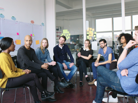 Menschen bilden einen Stuhlkreis.