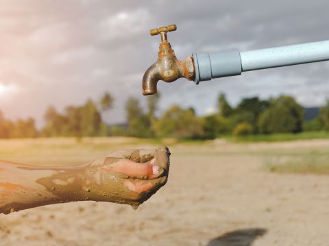 Schmutzige Hände unter einen Wasserhahn, aus dem kein Wasser kommt