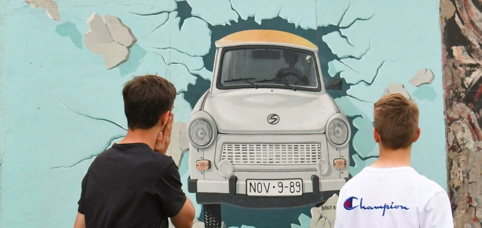 A Trabant bursts through the Wall, painted on the Wall. A Trabant bursts through the Wall, painted on the Wall.