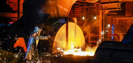 A steel worker in a protective suit at the blast furnace