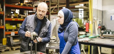 Un homme et une femme issus de la migration dans un atelier