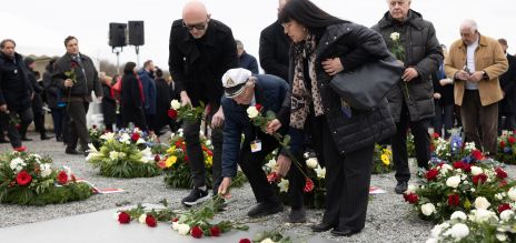 أندريه مويسينكو من بيلاروسيا، أحدُ الناجين من المحرقة النازية، يضع إكليلاً من الزهور.