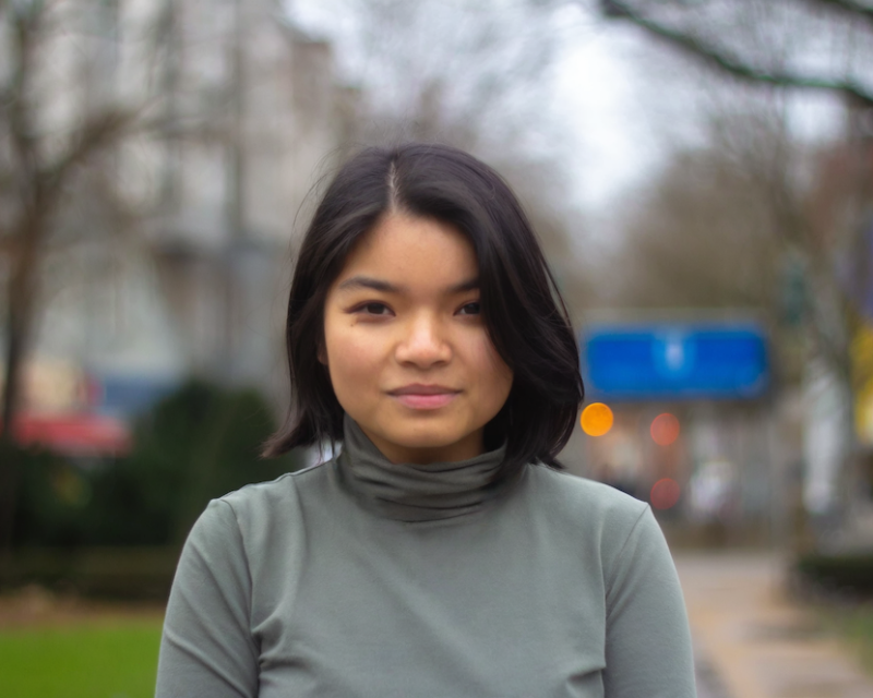 Eine junge Frau blickt in die Kamera. 