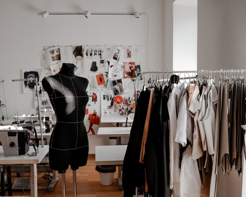 Ein Modeatelier mit Puppe, Kleiderständer und Nähtischen.