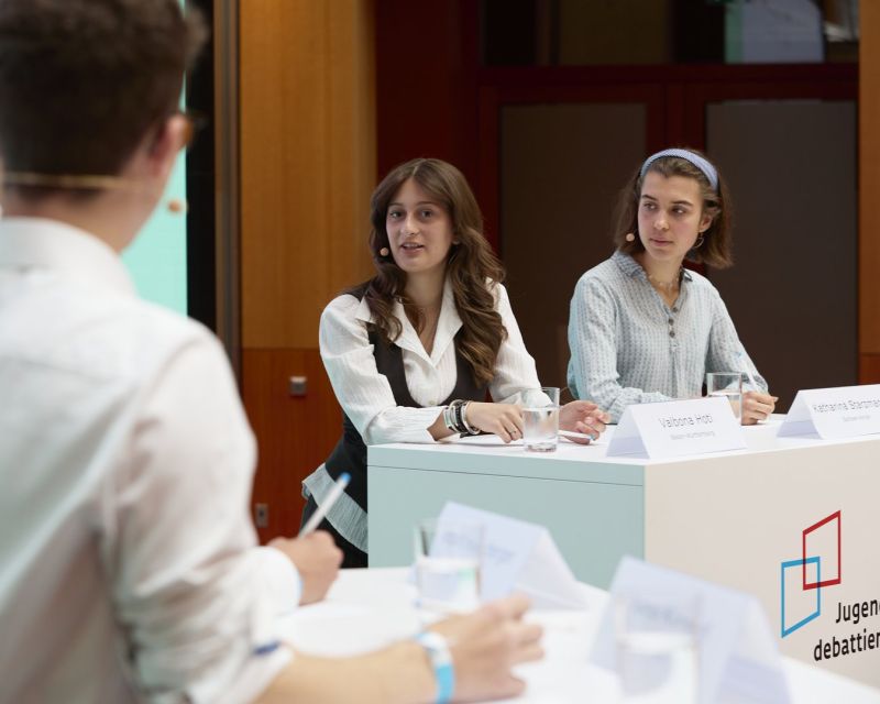 Zwei junge Frauen an einem Redepult