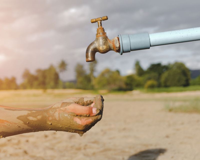 Schmutzige Hände unter einen Wasserhahn, aus dem kein Wasser kommt