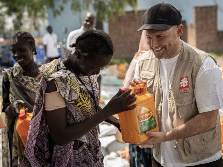 في كودوك بالقرب من الحدود مع السودان، (كيم كيركهوف) يسلّم سيدةً برميلاً من الزيت.