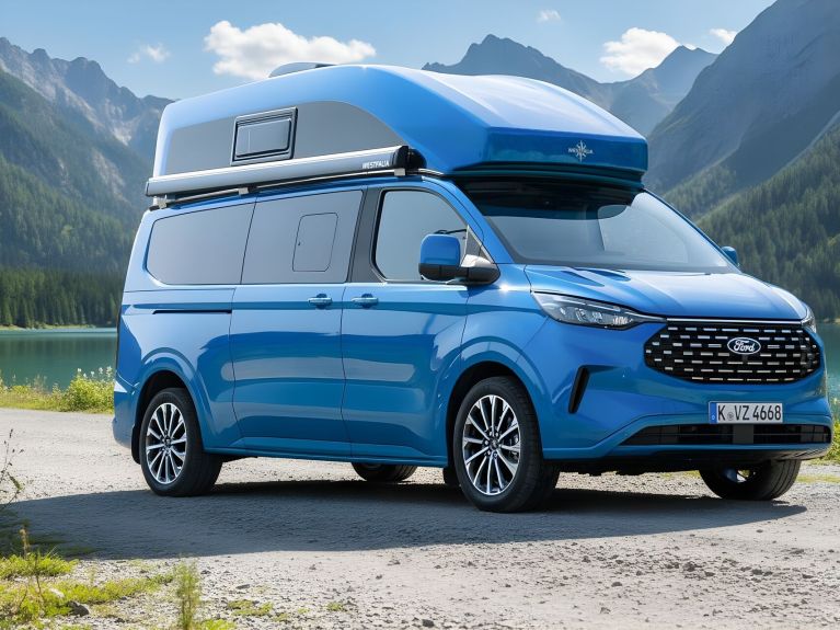 Blauer Campervan am  See vor Bergen.