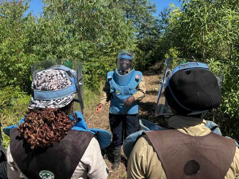 Deminer Rosemary Chigariro discusses the situation with her team. 