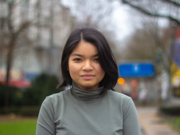 A young woman looks into the camera. 