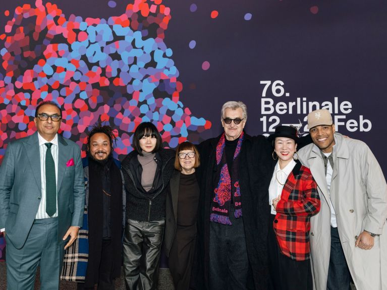 The international jury in 2026: (from left to right) Shivendra Singh Dungarpur, Min Bahadur Bham, Bae Doona, Ewa Puszczyńska, Wim Wenders, HIKARI, Reinaldo Marcus Green.