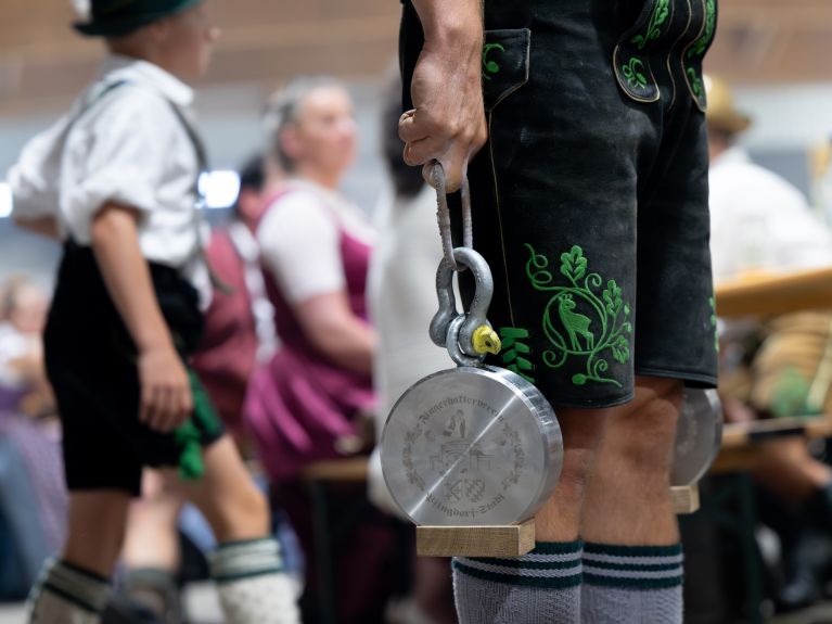 A person holds a weight with just one finger.