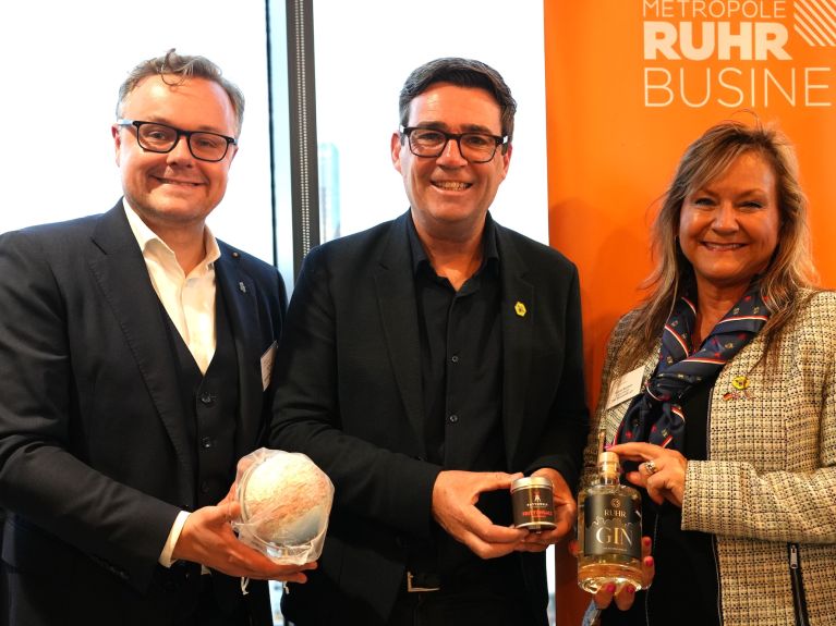 Jörg Kemna, Managing Director of Business Metropole Ruhr GmbH (left), presents gifts from the Ruhr region to Andy Burnham, Mayor of Greater Manchester (centre). 