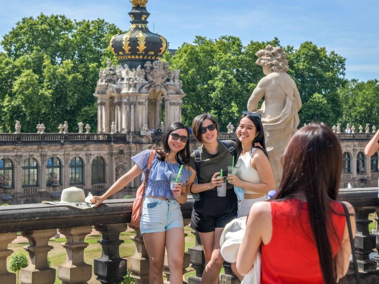 Chinesische Touristinnen am Zwingerhof mit Kronentor in Dresden 