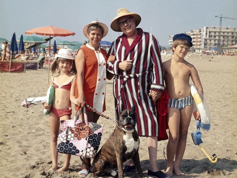 Eine Familie posiert für ein Foto am Strand.