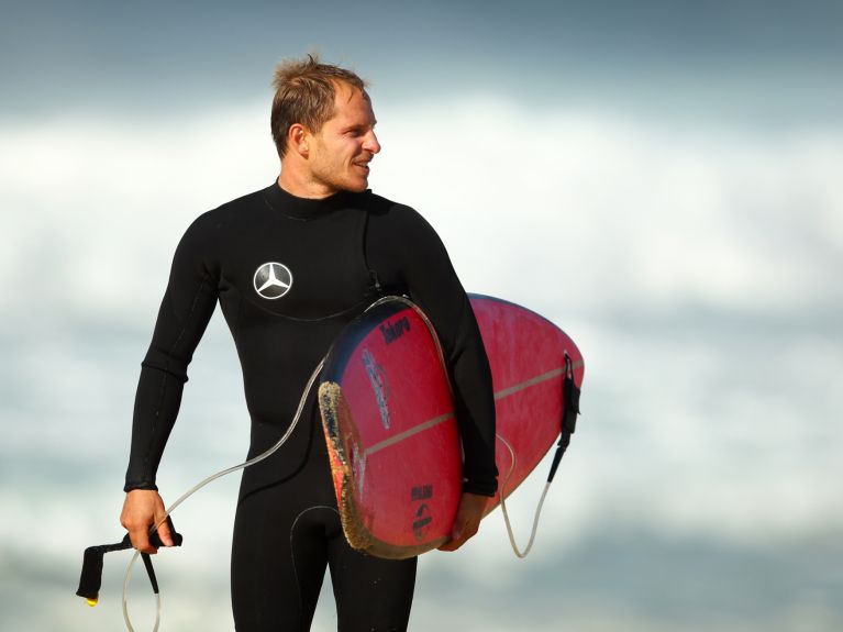 Surfer mit Surfbrett unter dem Arm