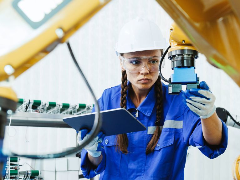 Frau bedient Roboter Frau bedient Roboter