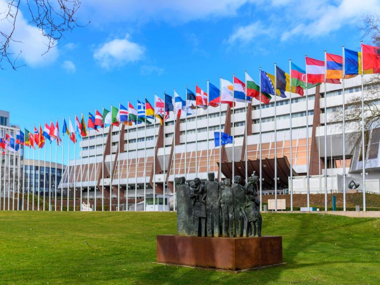 Landesflaggen und Denkmal für die Menschenrechte am Haupteingang des Europapalasts, dem Sitz des Europarats (Council of Europe / CoE) 