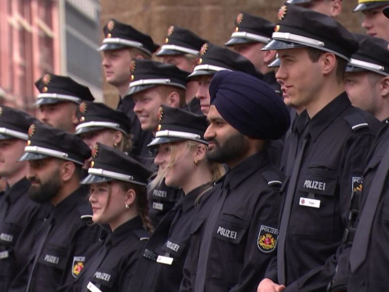 Mehrere junge Männer und Frauen in Polizeiuniform stehen auf  einer Treppe. Einer der Männer trägt einen Turban.