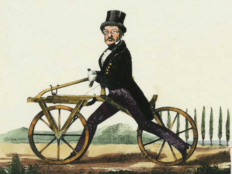 Karl Drais invented a two-wheeled “running machine” in 1817, known as the draisine or dandy horse (lithograph from 1891). 