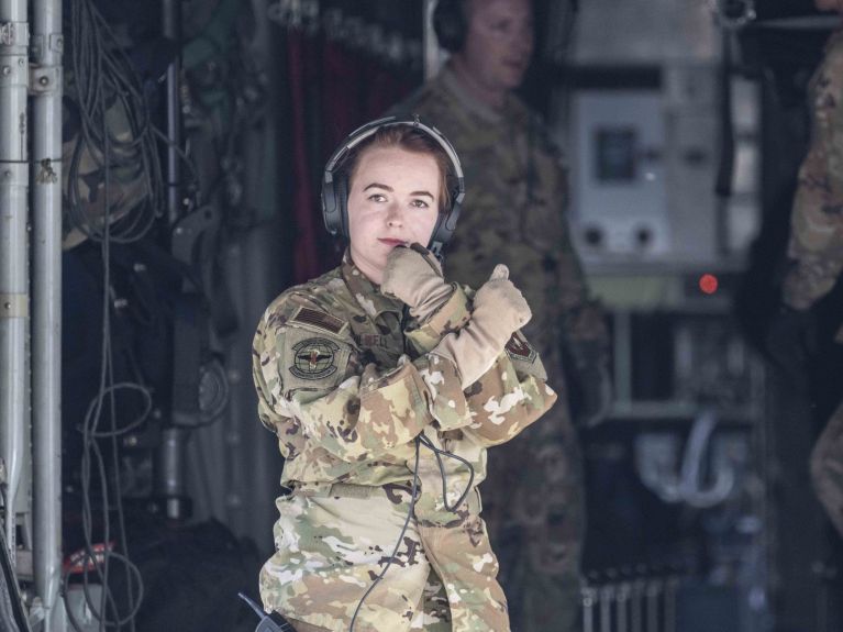 Una soldada en el acceso de un avión militar