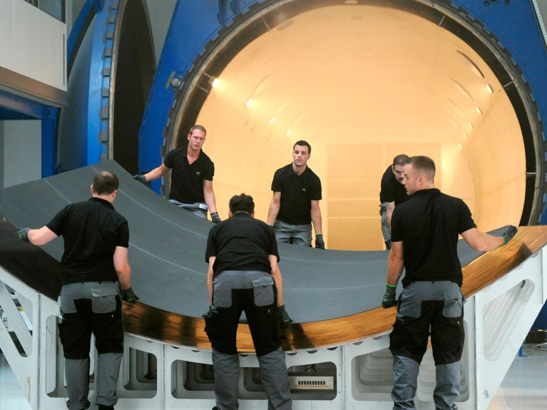 Employees removing a carbon-fibre mat from the ‘oven’ 