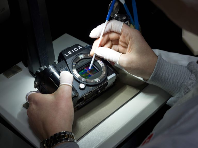 Eine Person prüft den Fotosensor einer Digitalkamera