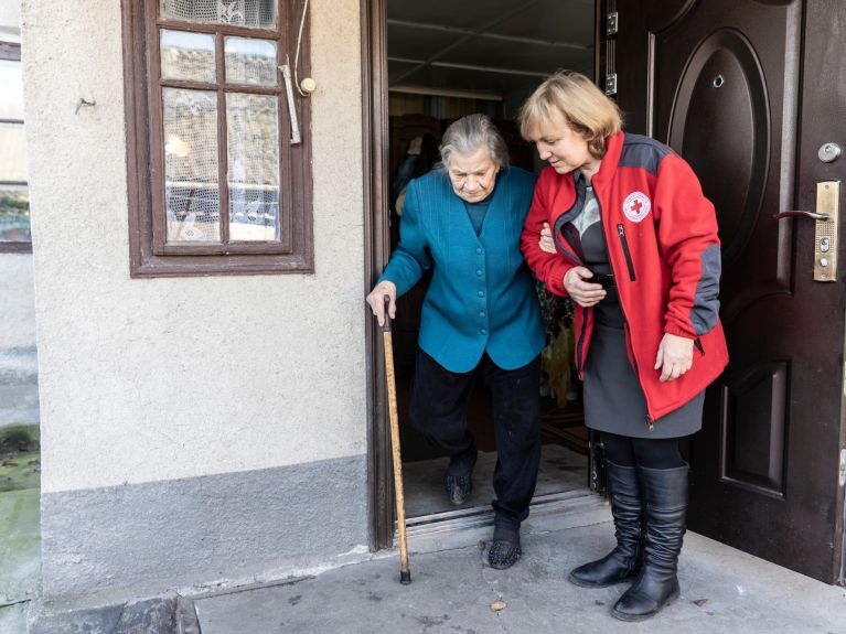 A pensioner in her home in Lanivtsi with a helper from the Ukrainian Red Cross.