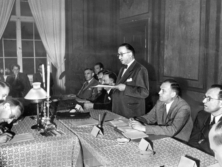 Historisches Foto: Ein Redner steht vor einer Gruppe Männern