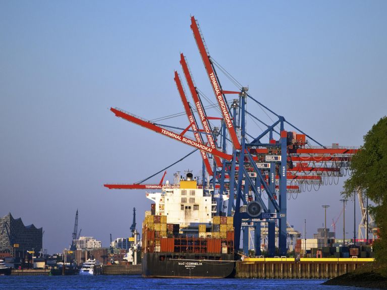 Ein Schiff hält vor Lastkränen am Hamburger Hafen