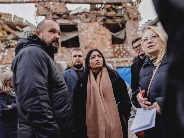 Reem Alabali Radovan beim Besuch eines zerstörten Wohnviertels in der Region Kyjiw 