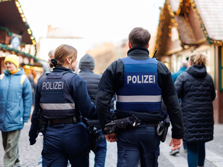 Policías patrullan por un mercado de Navidad. 