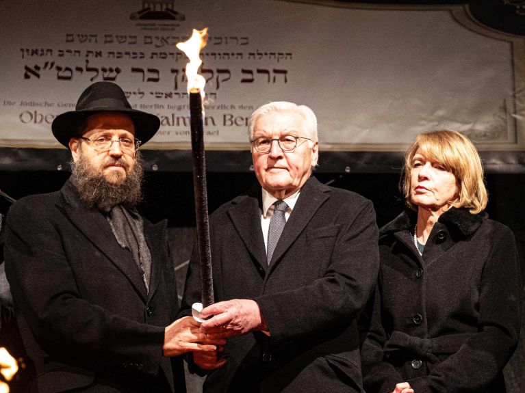 Rabbiner Yehuda Teichtal, Bundespräsident Frank-Walter Steinmeier und Elke Büdenbender entzünden am Sonntag die erste Chanukka-Kerze vor dem Brandenburger Tor. 