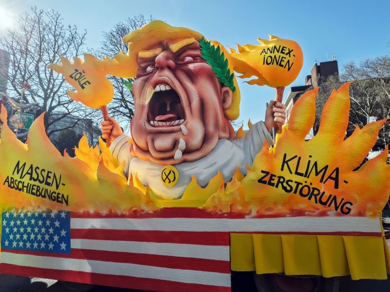 Satire requires garish colours: a float depicts Donald Trump surrounded by flames and slogans. 